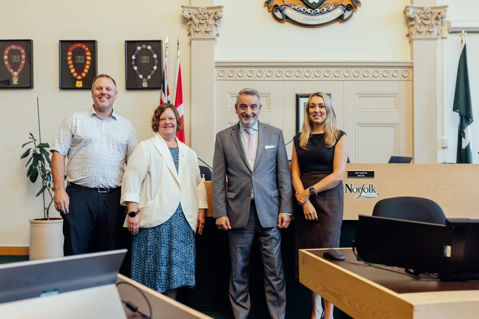 Above, left: Andrew Grice, General Manager, Environmental and Infrastructure Services, Heidy VanDyk, General Manager, Corporate Services, Minister of Municipal Affairs and Housing of Ontario, Paul Calandra, Mayor Amy Martin in Council Chambers, Simcoe.