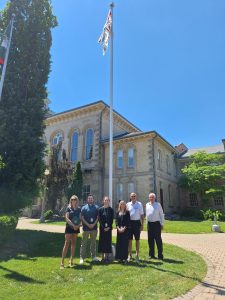 Above: Mayor Amy Martin (far left) and Councillor Chris Van Paassen (far right) are joined by summer student staff and David Horton (second from right), Chair of the Grand Erie Chapter of MS Society, at the County Administration Building in Simcoe to raise the MS Canada flag.